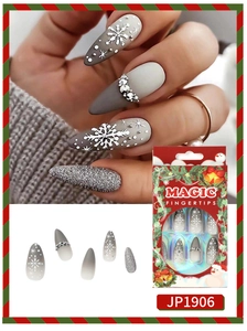 Close-up of almond Christmas nails with snowflake prints and rhinestone details