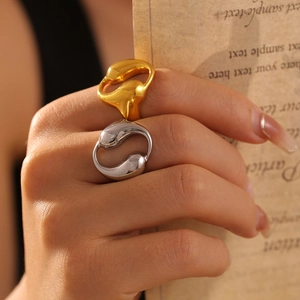 Minimalist dual teardrop hollow ring in 18k gold and silver finish on vintage paper background