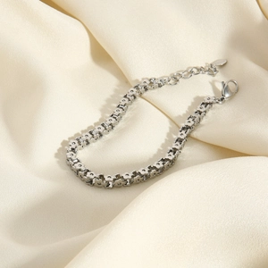 Men's silver stainless steel bracelet with floral link pattern on beige silk background
