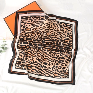Leopard print silk scarf with luxury orange gift box on white wrinkled fabric