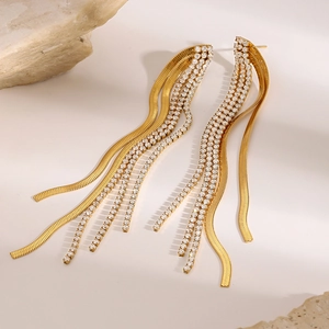 Detail of gold long tassel earrings with sparkling rhinestones and snake chains