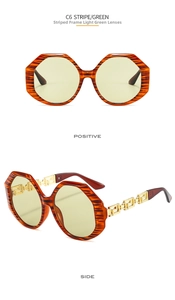 Detail of baroque sunglasses with Greek meander cutout metal temples and stripe frame