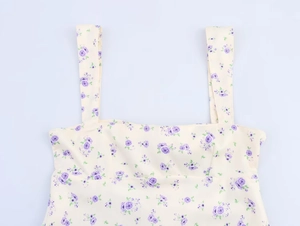 Détail du haut à bretelles d'été avec motif floral violet sur tissu blanc cassé