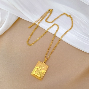 Macro shot of gold Fu character dragon pendant necklace on white silk fabric background