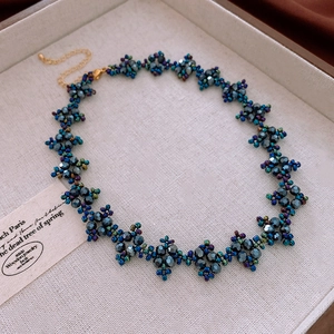 Vue détaillée d'un collier de perles facettées bleu foncé avec fermoir mousqueton doré