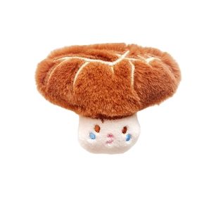 Cute mushroom plush brooch with brown cap and embroidered face on white background