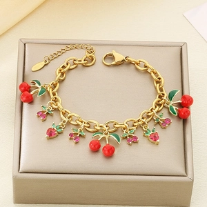 Close-up of gold stainless steel bracelet with zircon strawberry and cherry fruit charms