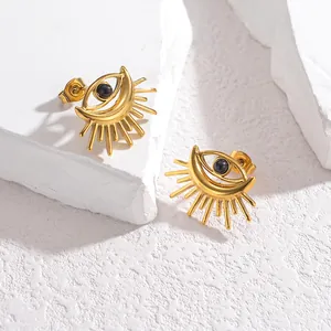 Retro golden evil eye earrings with radiant sunburst lashes on textured white stone