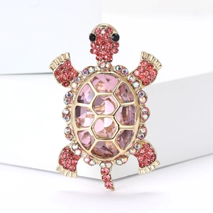 Macro detail of turtle brooch with pink faceted crystal and rhinestones on gold base