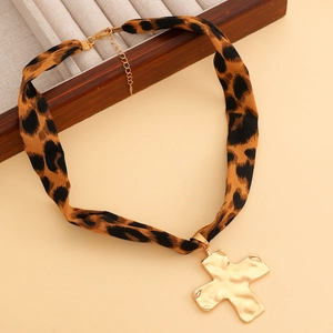 Detail-Ansicht vom Leoparden-Stoff-Choker mit goldenem Kreuzanhänger und Verlängerungskette