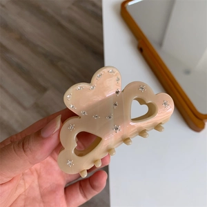 Detail of pink-beige gradient heart hair claw with sparkling rhinestone embellishments