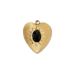 Close-up of golden heart pendant with black oval gemstone and sunburst texture