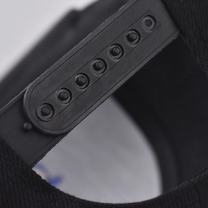 Gros plan détaillé de la fermeture snapback en plastique noir sur la casquette en coton