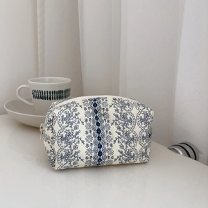 Detail of blue floral quilted makeup bag with soft cotton texture and zipper closure