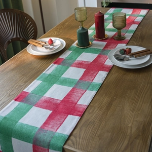 Christmas plaid table runner with red green and white checkers on dark wood table