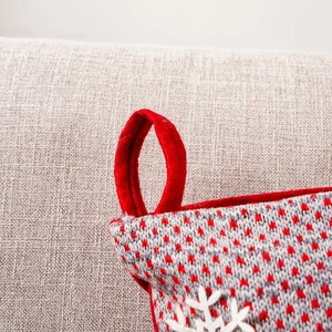 Nahaufnahme eines gestrickten Weihnachtssocken-Details mit roter Schlaufe und Schneeflocke
