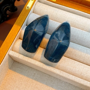 Detailed close-up of blue marble-textured irregular resin geometric stud earrings