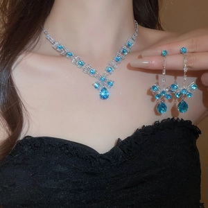 Blue teardrop zircon necklace and earrings set worn by model in elegant black dress