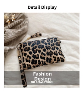 Detail of leopard print clutch featuring a gold zipper and stylish fringe tassel