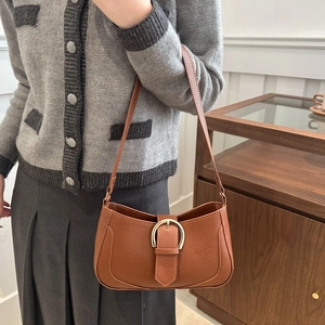 Detailed view of the brown litchi pattern leather shoulder bag with golden hardware buckle