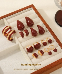 Close-up of vintage deep red enamel earrings in heart and drop shapes on display