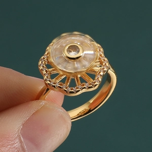 Detailed macro shot of golden spinning ring with sunburst flower and zircon inlay