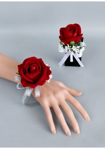 Detailed view of red velvet rose corsage and wrist flower set for wedding ceremonies