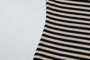 Gros plan sur la texture du tricot rayé et la couture latérale du haut ajusté