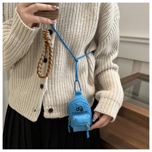 Detail of blue mini backpack coin purse with braided handle and long neck strap