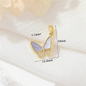 Macro shot of 14k gold butterfly pendant with cubic zirconia and size specs