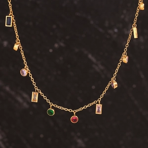Macro detail of 18K gold plated necklace with colorful round and rectangular zircons