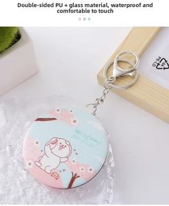 Detail of portable mini folding mirror with PU leather texture and metal keychain