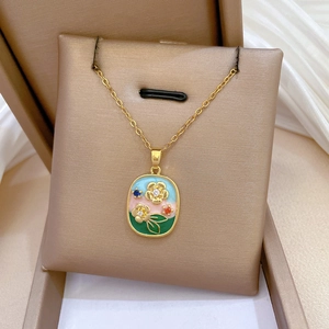 Detail of gold enamel necklace featuring floral oil painting pendant with small crystals