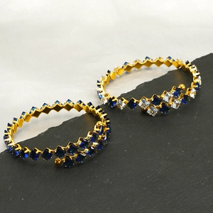 Gold open bangles with square blue and white zircon pavé on black stone and white silk