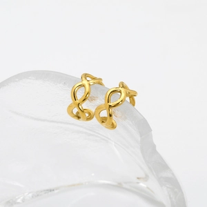 Detailed view of gold infinity double layer ear cuff on a transparent glass surface