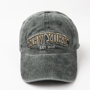 Detail of embroidered NEW YORK EST. 1625 text on washed cotton denim baseball cap