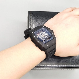 Close-up of skeleton mechanical watch with tonneau case and black silicone strap