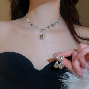 Detail of luxury necklace and earrings set with amber water-drop stones and crystals