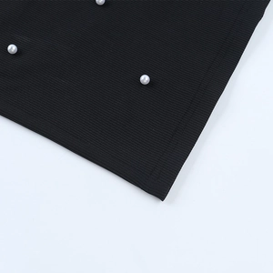 Gros plan sur un tricot noir côtelé orné de perles blanches pour une robe de soirée