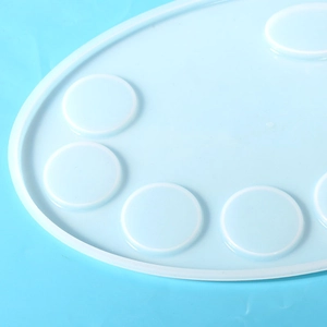 Detail shot of light blue silicone resin mold featuring a painter palette design and round slots