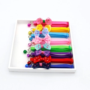 8-piece adjustable pet collar set with polka dot bows and bells on a white tray