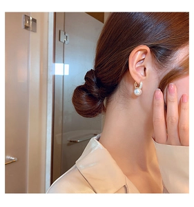 Close-up of pearl drop earrings with gold hoop on model showing elegant style