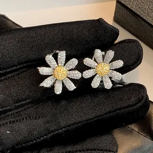 Macro shot of silver daisy earrings with white and yellow sparkling cubic zirconia