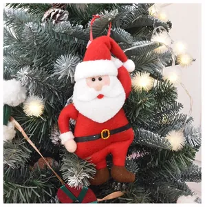 Detail of felt Santa Claus ornament hanging on Christmas tree with warm lights and pinecones