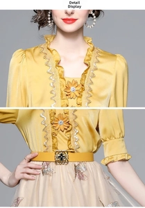 Detail of yellow silk-like blouse with 3D flower, ruffle collar and butterfly embroidery