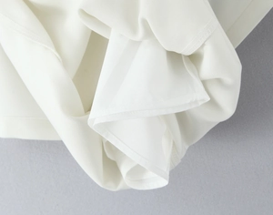Detailed view of white lace set showing premium lining and refined hemming craftsmanship