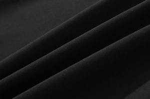 Vue macro de la texture du tissu en maille noire et détails plissés de la jupe sirène