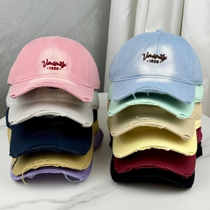 Close-up of distressed brim details and vintage varsity embroidery on cotton baseball caps