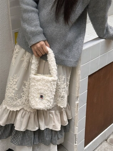 Detail of white plush insulated cup carrier featuring a black cat embroidery patch