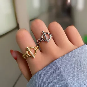 Detail view of gold and silver OT buckle chain rings with rhinestones on fingers
